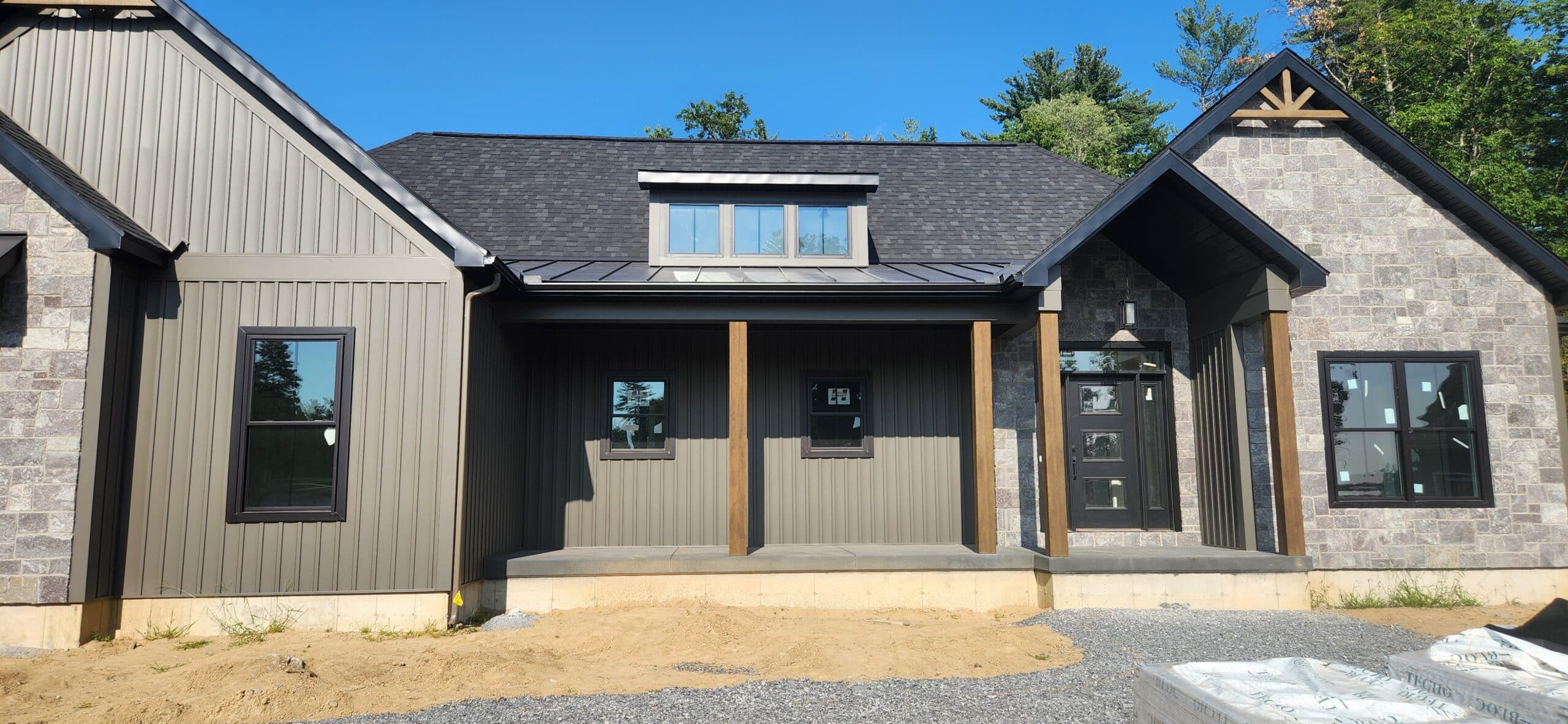 A new gutter system installed on the front of a tan house